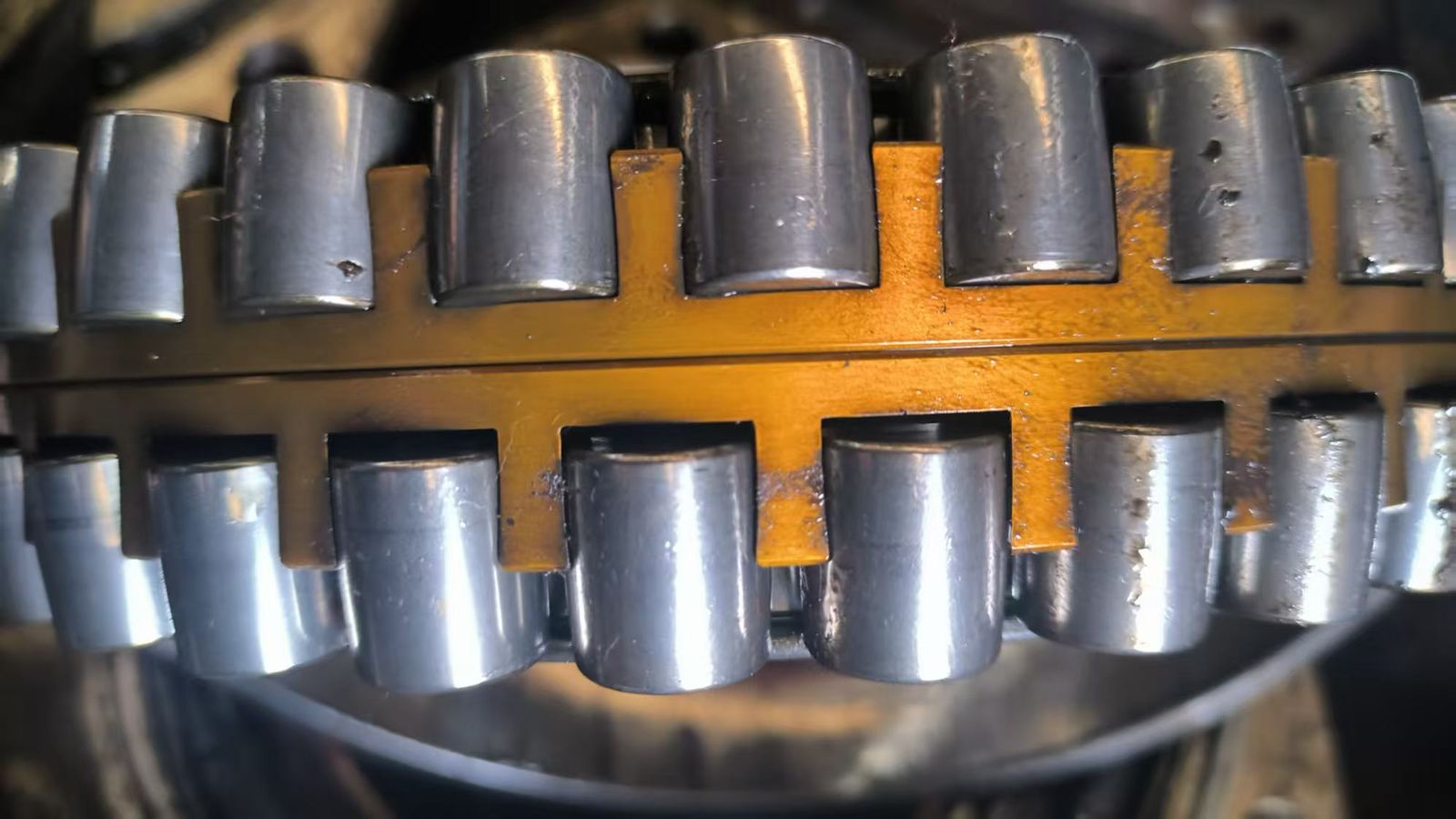 機加工黃銅滾動軸承保持架特寫，兩排鋼製滾動體，無品牌標識