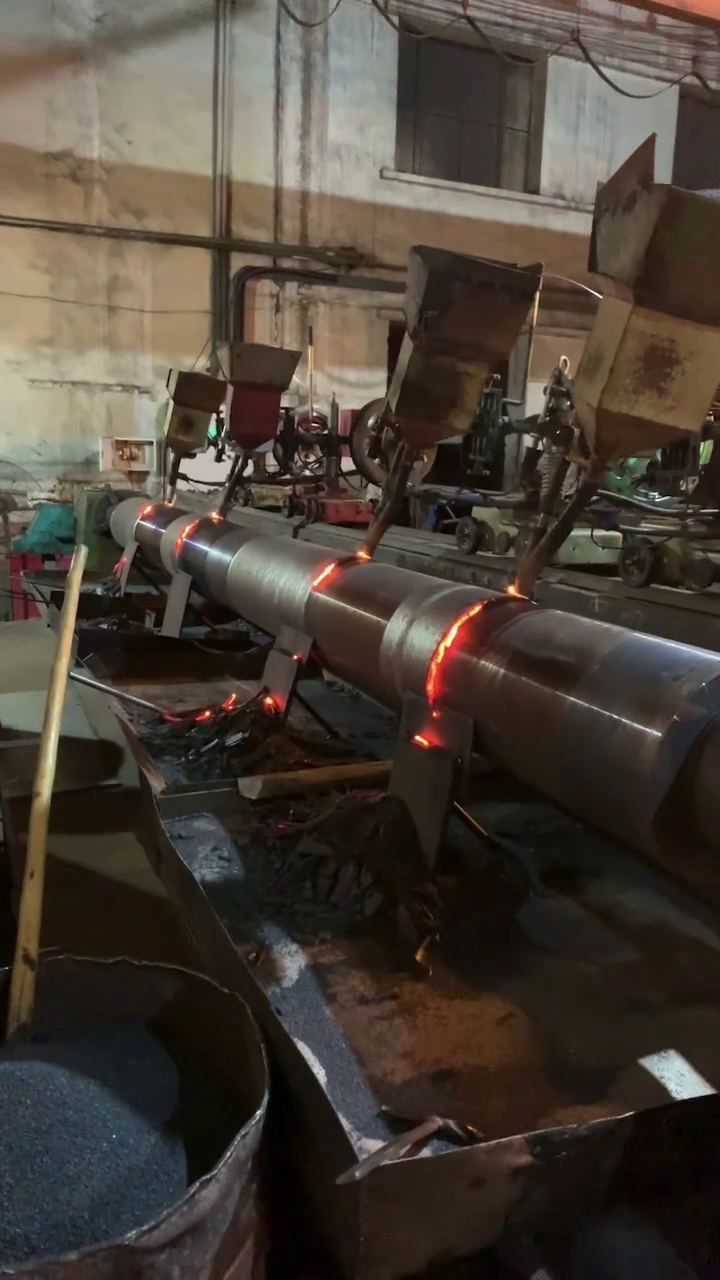 長矯直機輥通過堆焊再製造，焊道熾紅，多個焊頭同時作業
